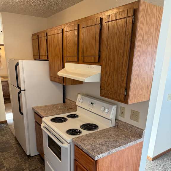 a kitchen with a white oven and wooden cabinets.