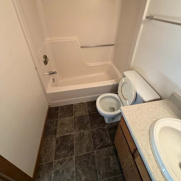 a white bathtub with a shower head and a shower curtain rod.