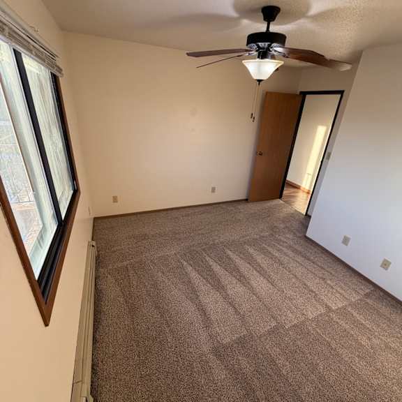 a room with a window and a fan on the wall.