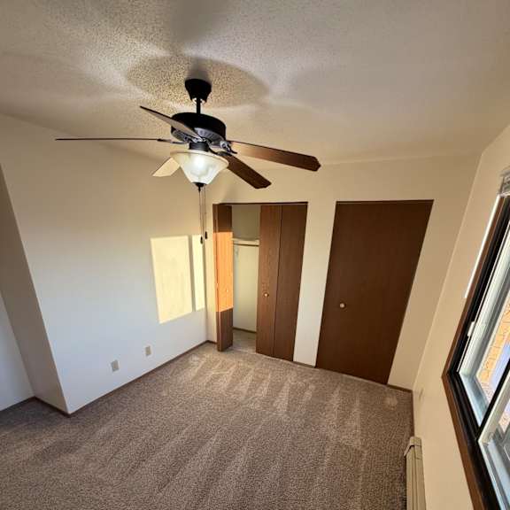 a ceiling fan is mounted on a wall in a room with a skylight.
