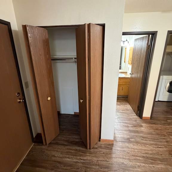 a wooden drawer with a black handle is in a cabinet.