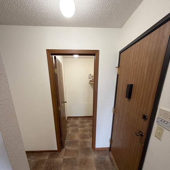 a mirror is mounted on a wall above a wooden ledge.