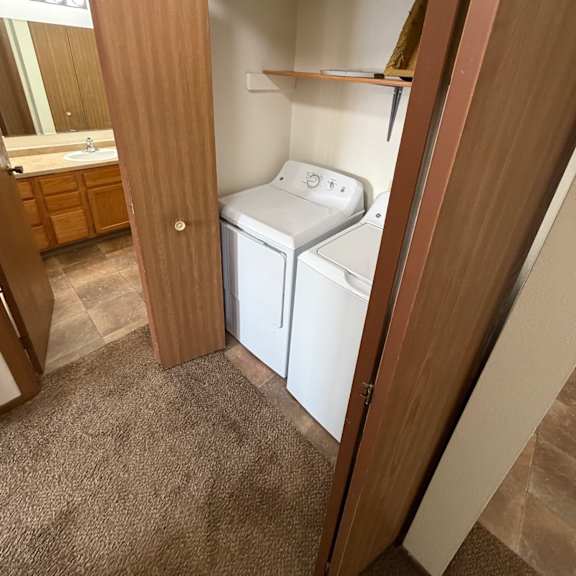 a white electrical outlet is on a brown wooden shelf.