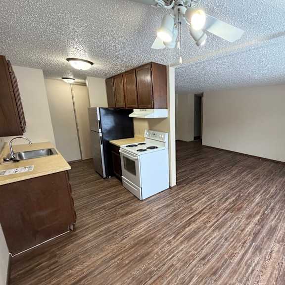 a kitchen with a white stove top oven and a black refrigerator.
