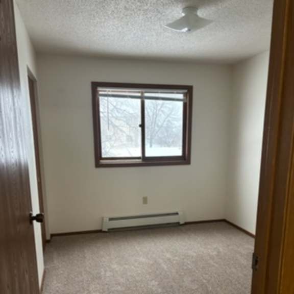 a room with a window and a radiator on the wall.