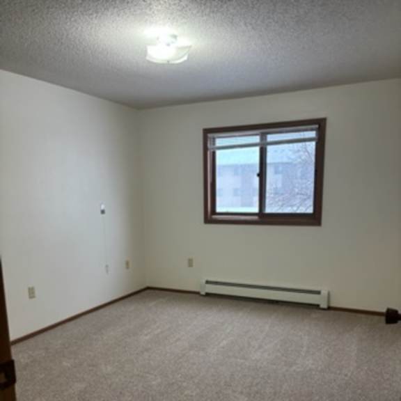 a room with a window and a radiator on the wall.