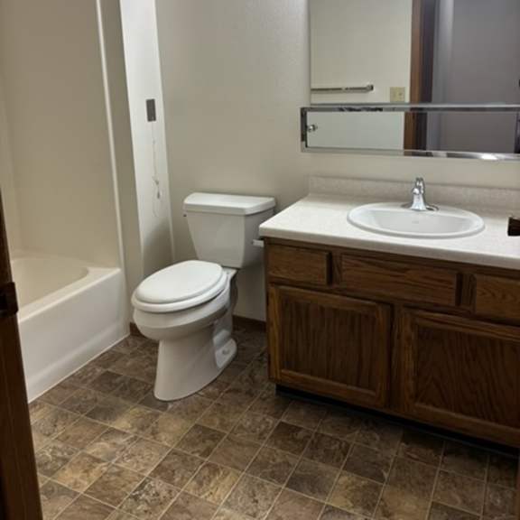 a white toilet sits in a bathroom next to a sink.