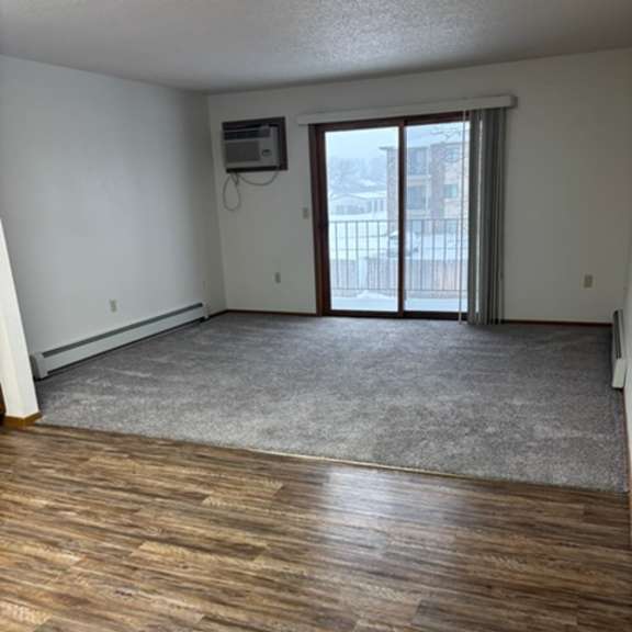 a room with wooden flooring and a sliding glass door.