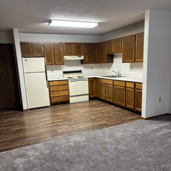 a kitchen with wooden cabinets and a white fridge.