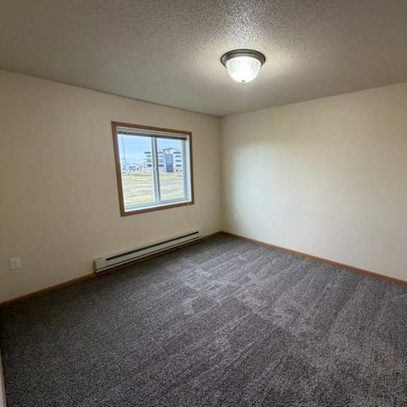 a room with a carpeted floor and a window.