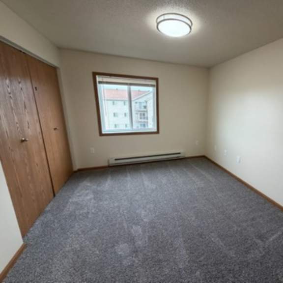 a room with a carpeted floor and a window.