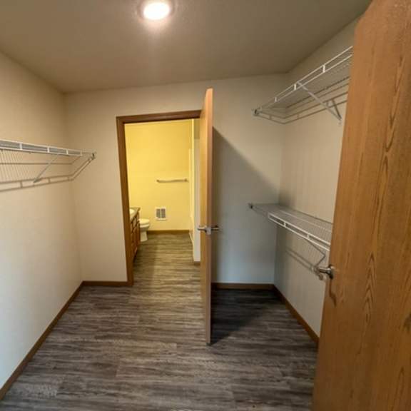 a walk-in closet with a yellow door and shelves.