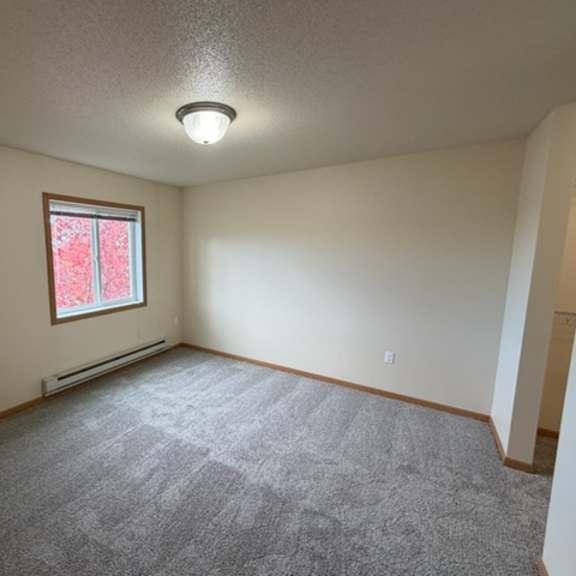 a room with a carpeted floor and a window.