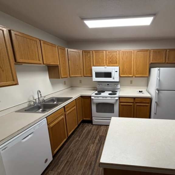 a kitchen with wooden cabinets and white appliances.