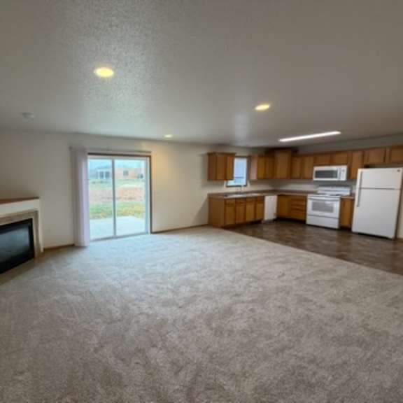 a living room with a television and sliding glass doors.