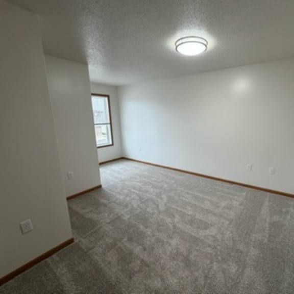 a room with a carpeted floor and a window on the wall.