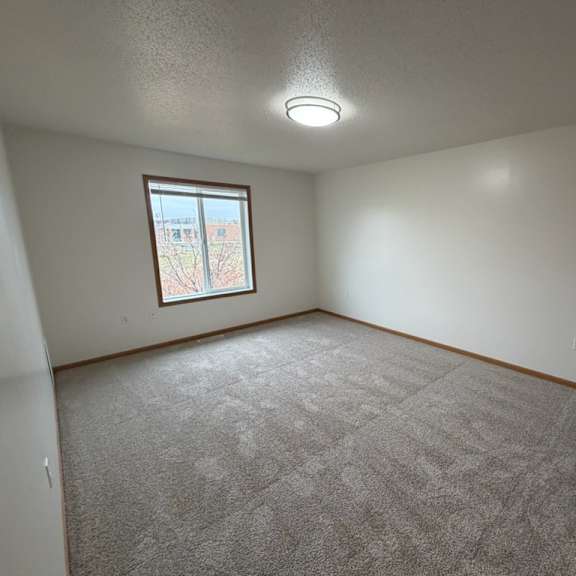 a room with a carpeted floor and a window.