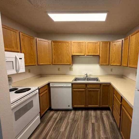 a kitchen with wooden cabinets and a white refrigerator.