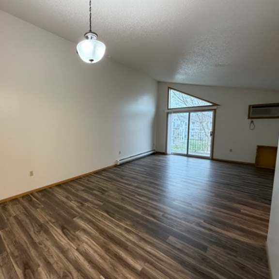 a room with wooden flooring and a hanging light fixture.