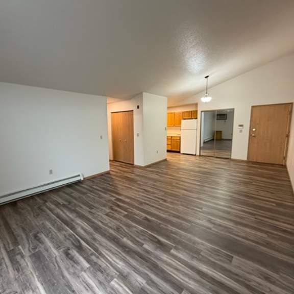 a room with wooden flooring and white walls.
