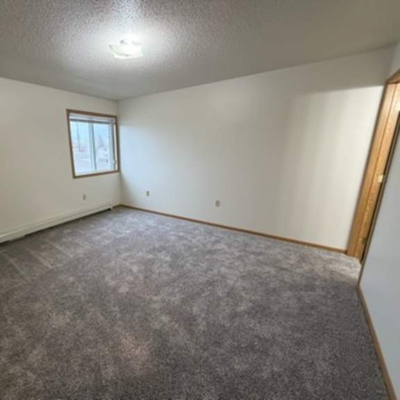 a room with a carpeted floor and a window.