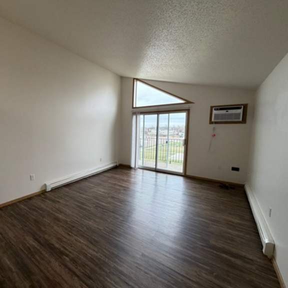 a room with wooden flooring and a window.