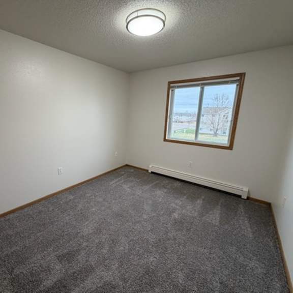 a room with a carpeted floor and a window.
