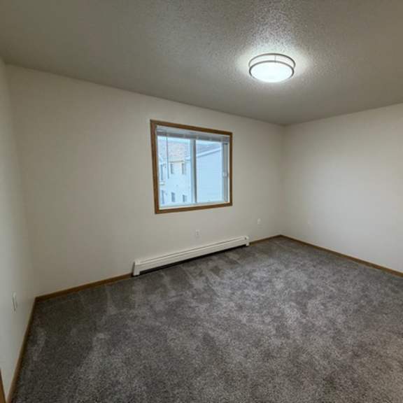 a room with a carpeted floor and a window.