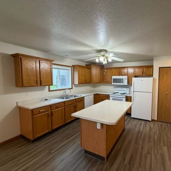 a kitchen with wooden cabinets and a white countertop.