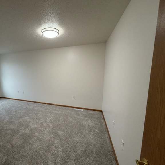 a room with a carpeted floor and a window.