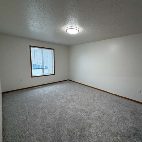 a room with a carpeted floor and a window.