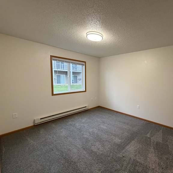 a room with a window and a carpeted floor.