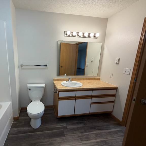 a bathroom with a white tub, toilet, and sink.