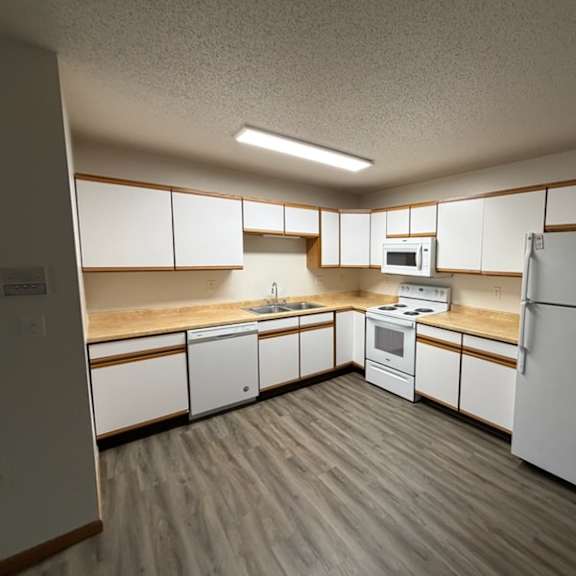 a kitchen with white appliances and wooden accents.