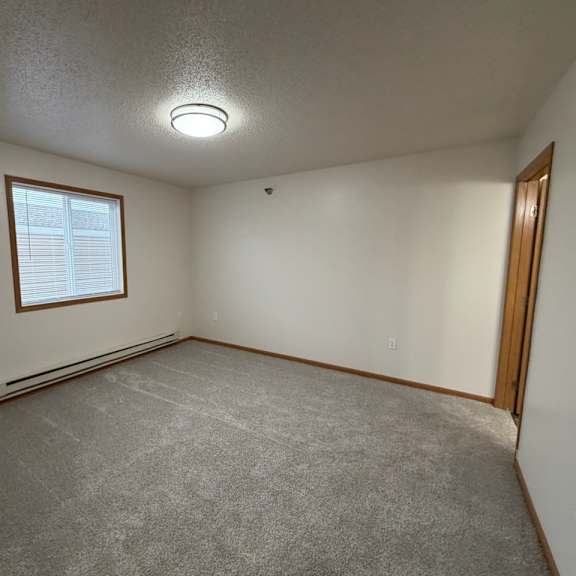 a room with a carpeted floor and a window.