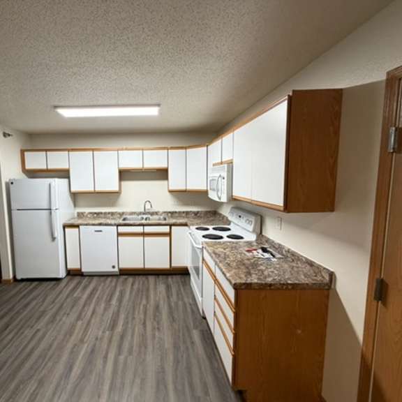 a kitchen with white appliances and wooden cabinets.
