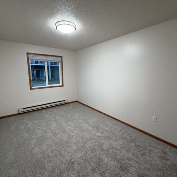 a room with a carpeted floor and a window.