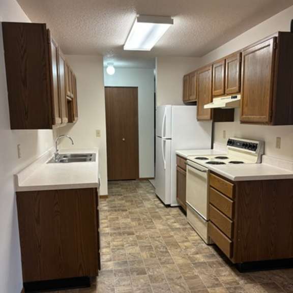 a kitchen with brown cabinets and white appliances.