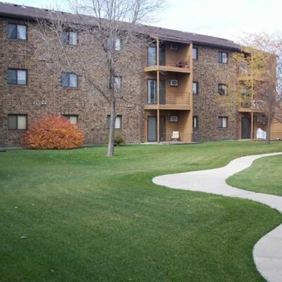 apartment complex with a walkway in the grassy area.