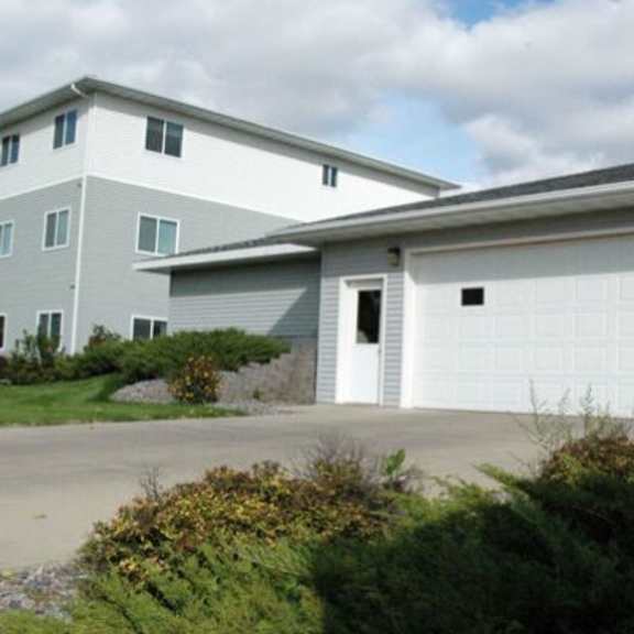 apartment building with a grey and white exterior and a garage door.