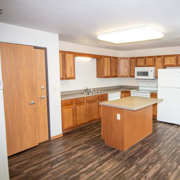 a kitchen with wooden floors and white appliances.
