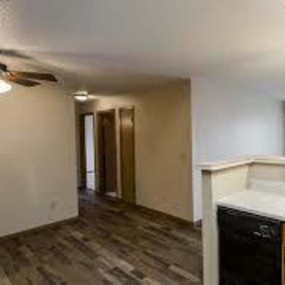 a kitchen with a black dishwasher and wooden cabinets.