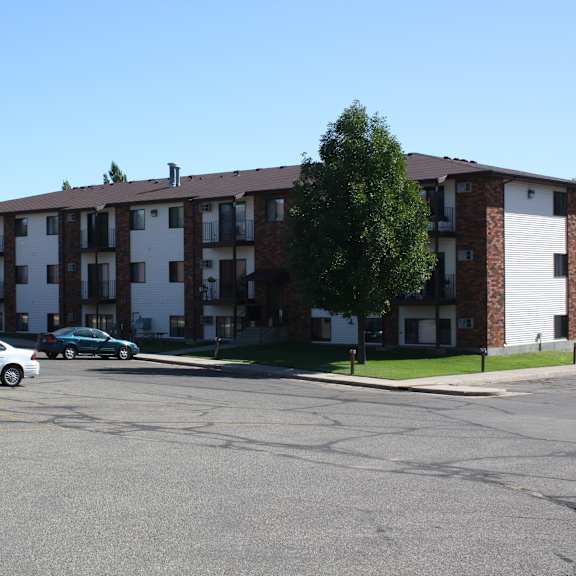 a parking lot with cars and a building in the background.