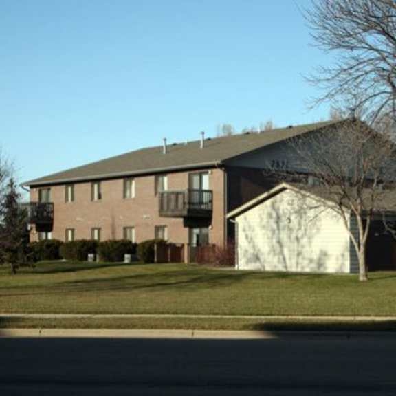 a large building with a white garage door is in the background.
