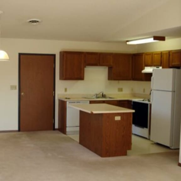 a kitchen with white appliances and brown cabinets.