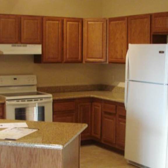 a kitchen with a white fridge and wooden cabinets.