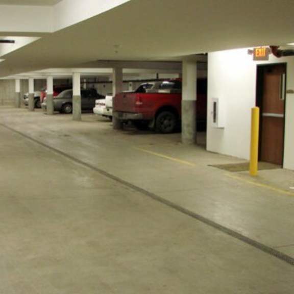 a parking garage with a red car parked in the middle.