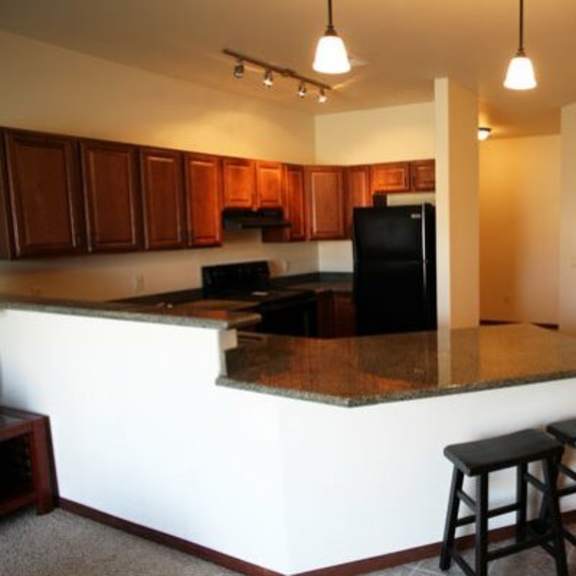 a kitchen with a bar area and a dining table.
