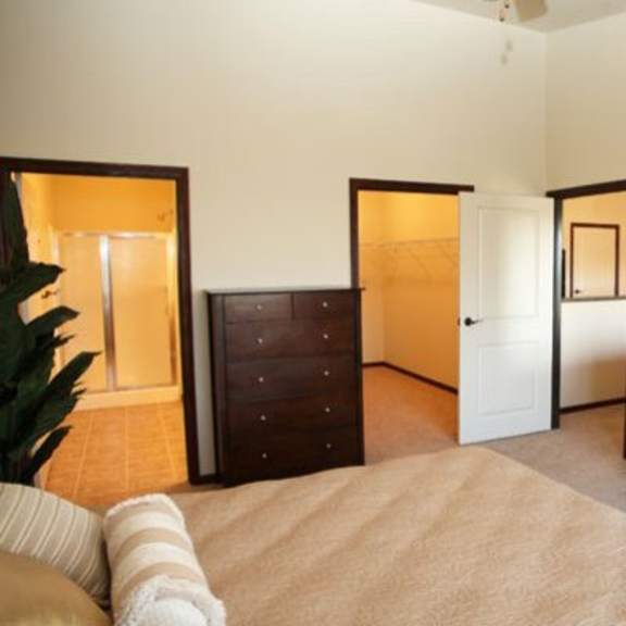 a bedroom with a bed, dresser, and mirror.