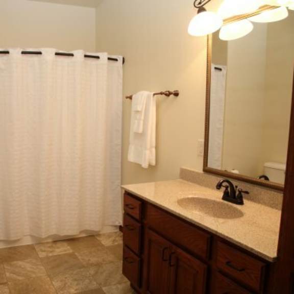 a bathroom with a toilet, sink, and shower curtain.